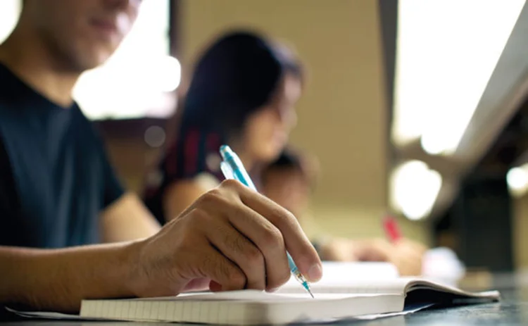 A student taking exam notes on a note pad